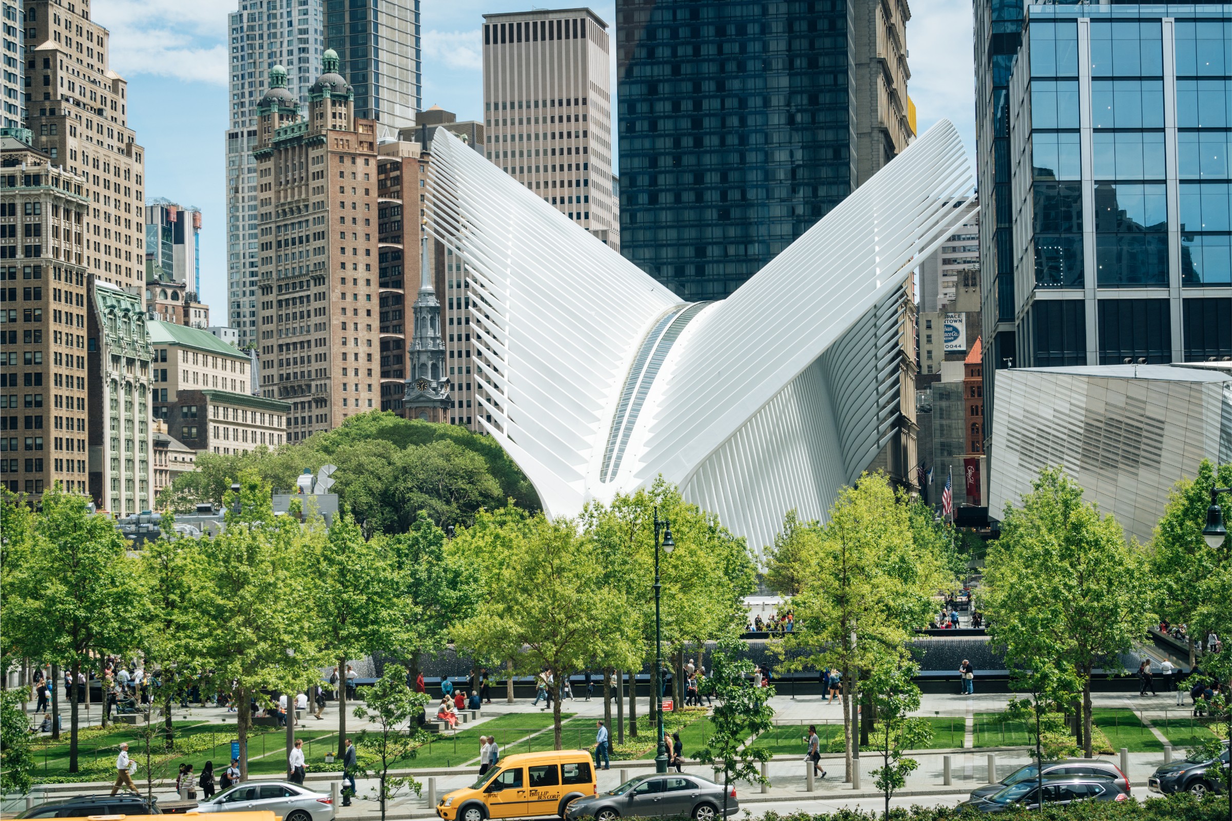 Oculus-rakennus New Yorkissa kuvattuna puiston ja pilvenpiirtäjien keskeltä