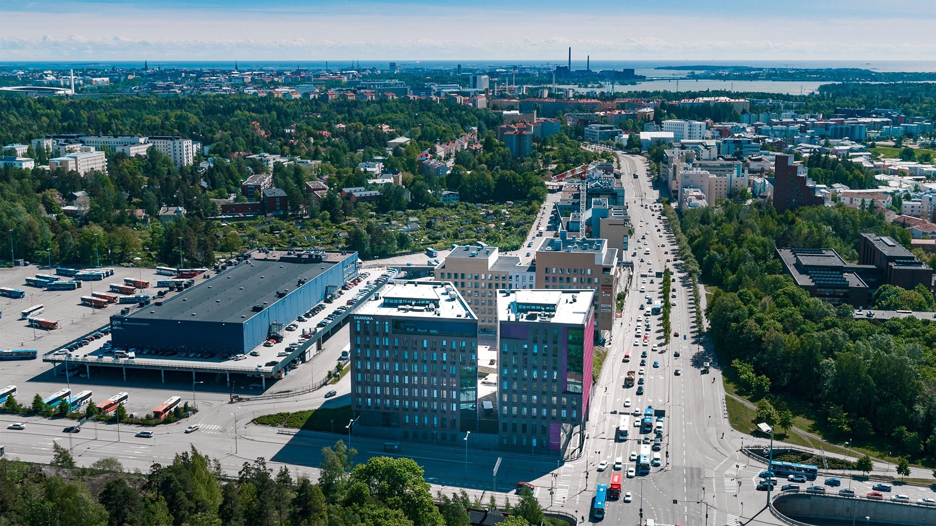 Ilmakuva modernista kaupunkimaisemasta Helsingissä, Suomessa Ilmakuva vilkkaasta kaupunkialueesta, jossa on moderneja rakennuksia, teitä ja rehevää kasvillisuutta Helsingissä.