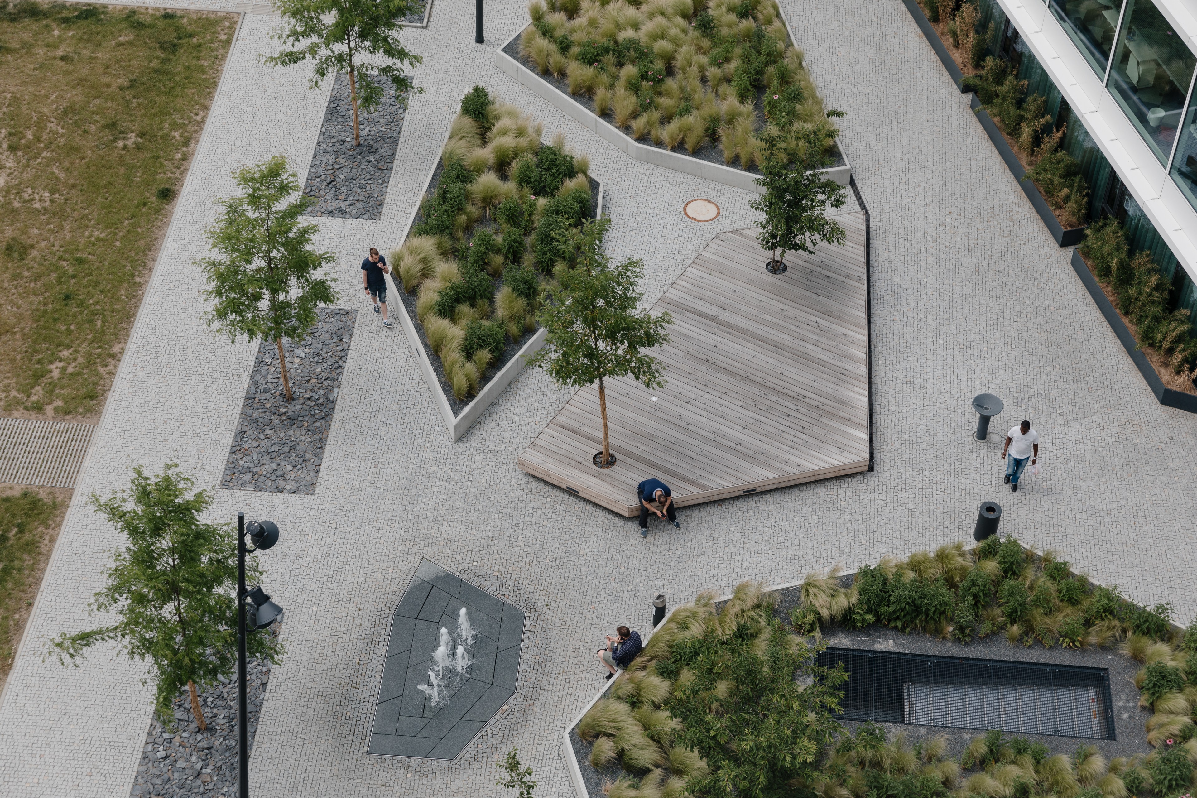 Visionary courtyard Aerial view of a modern urban park with trees, plants, benches, and paths.