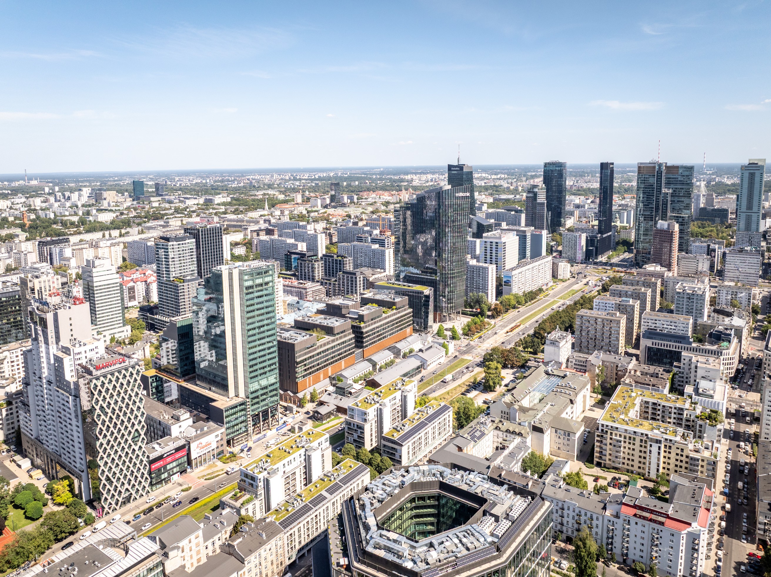 A bird's-eye view of modern skyscrapers and urban architecture in Warsaw, Poland on a sunny day.