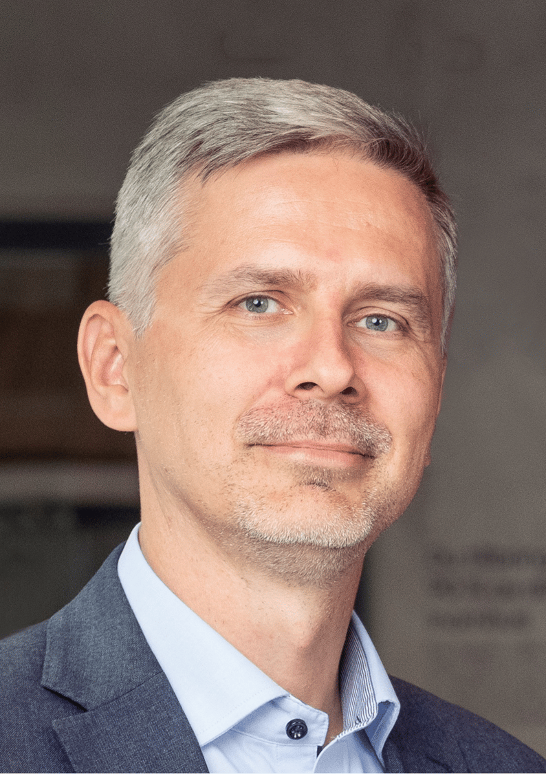 Man klädd i kavaj och ljusblå skjorta