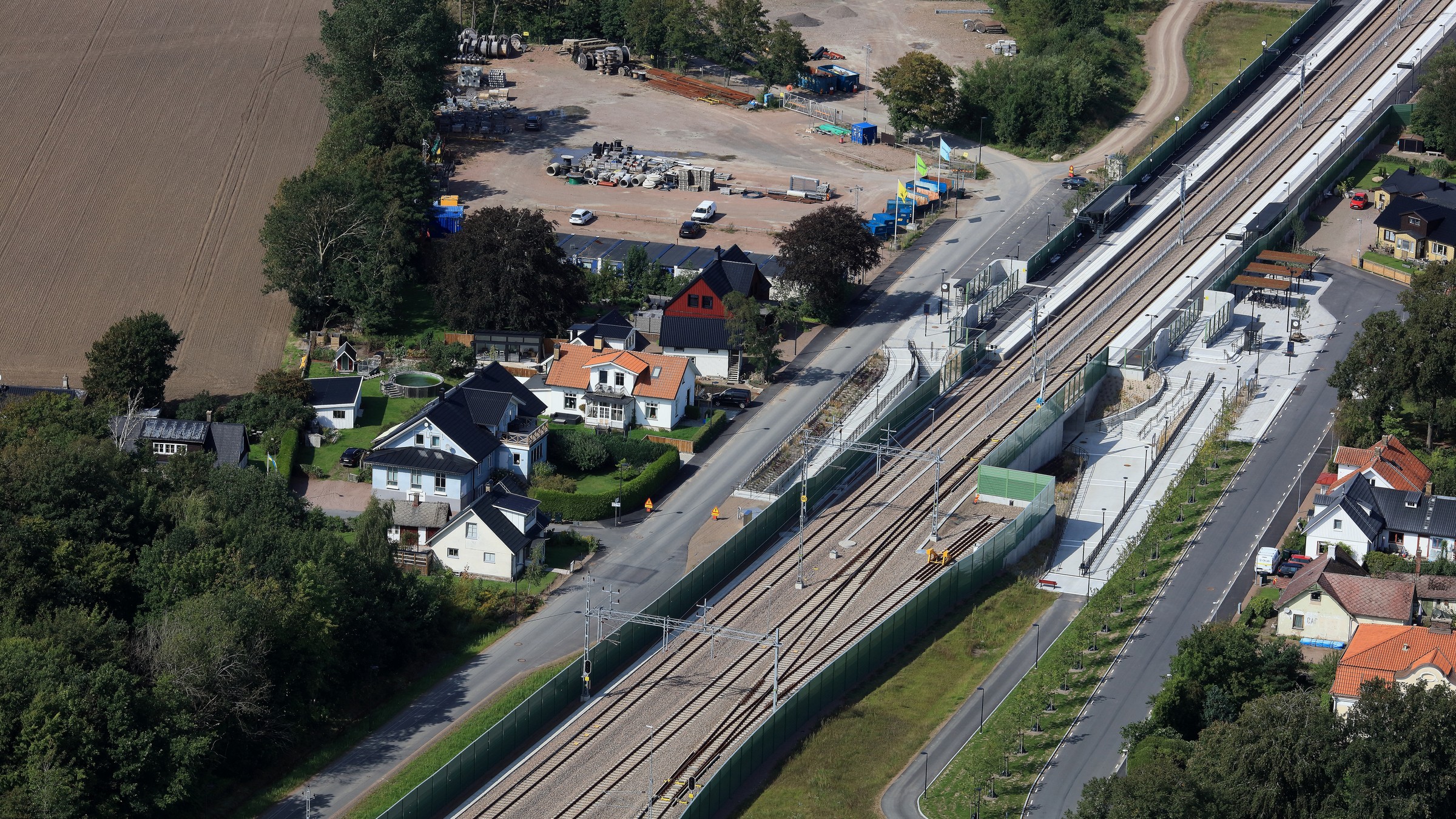 Kattarps stationsområde anpassas till det nya spåret och ökat resande som förväntas ske i framtiden. Järnväg med stationsbyggnad fotad ovanifrån med drönare.