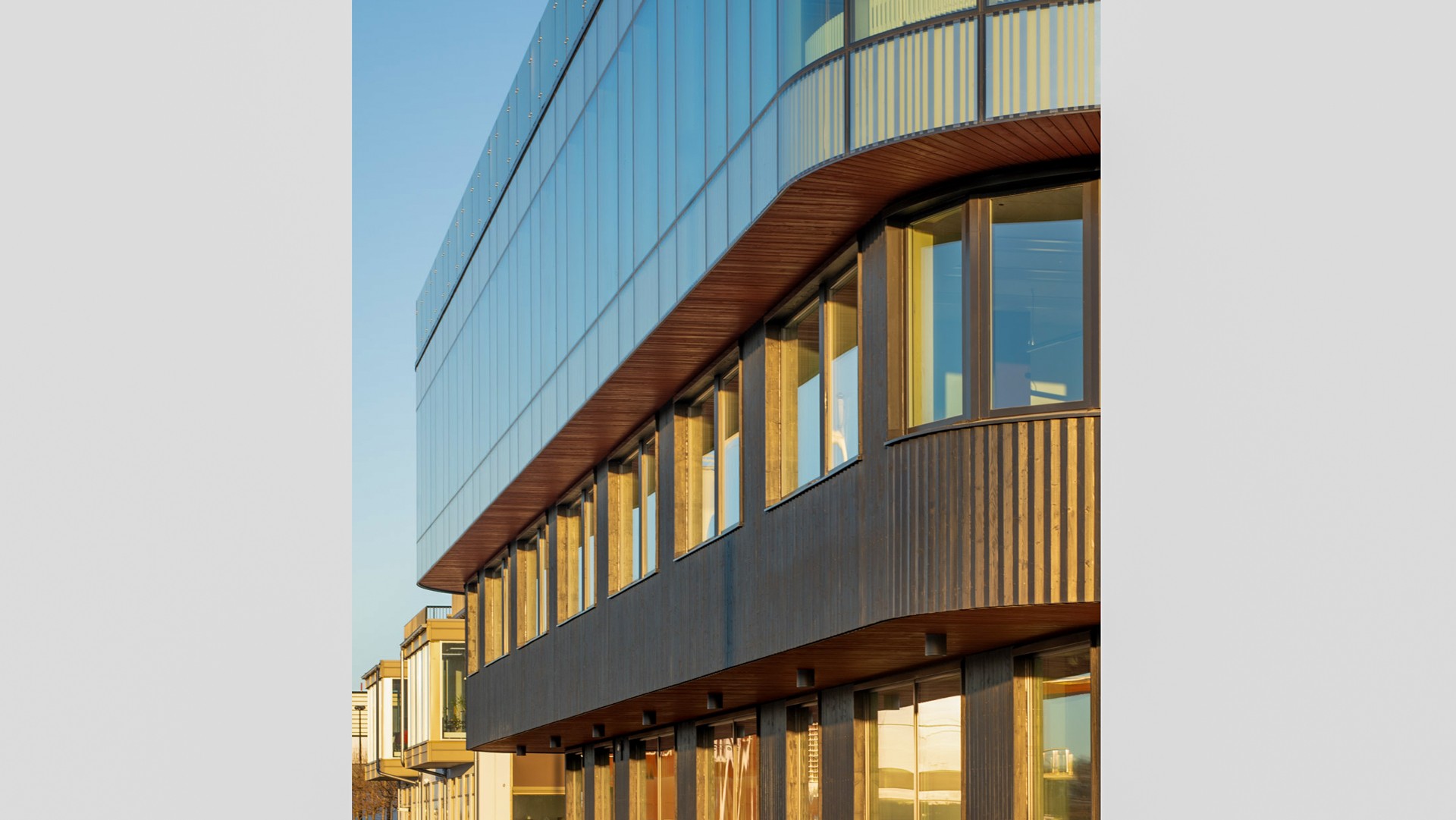 Skanskas höga hållbarhetsambitioner för projektet sätter en helt ny standard för hur vi vill bygga i framtiden. Foto: Anders Bobert Glasad fasad med trädetaljer och speglingar från omgivningen.