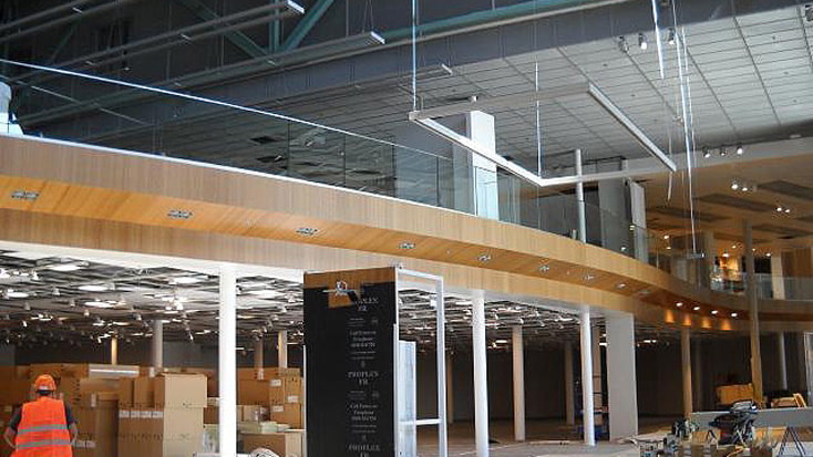 Byggarbetsplats för en modern byggnadsinteriör med glasräcken och staplade lådor.