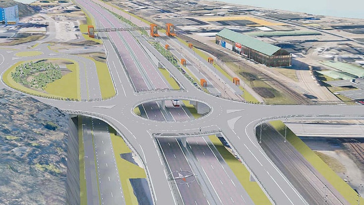 Flygvy över en modern motorvägsknutpunkt med flera körfält och en rondell för smidig trafikflöde.