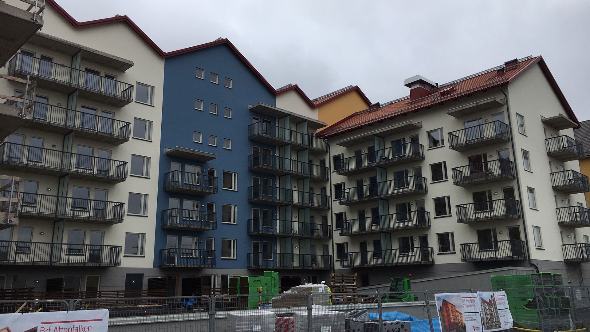 Modernt lägenhetskomplex under uppbyggnad med färgglada fasader och balkonger.