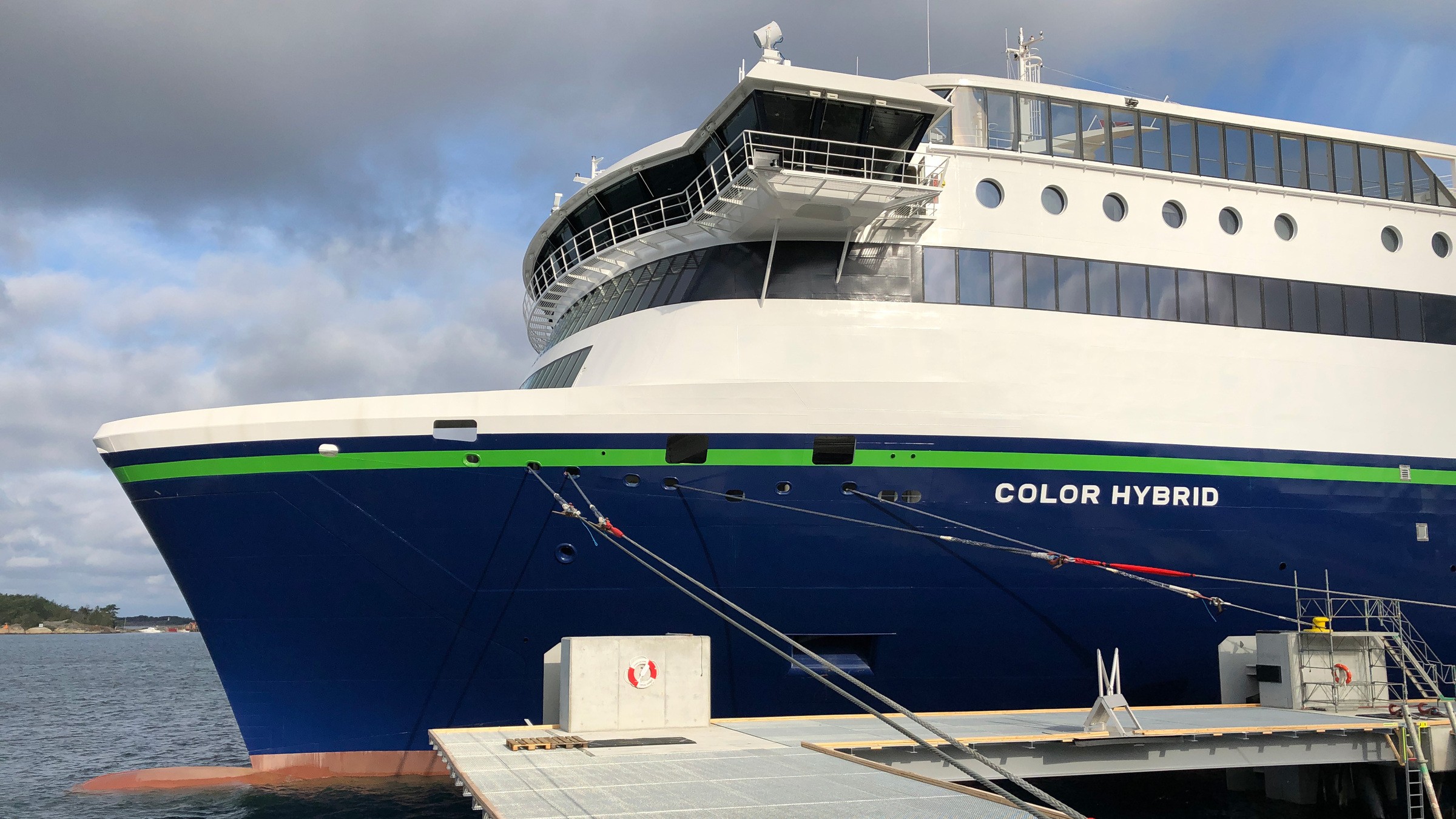 För att den nya färjan skulle kunna lägga till behövde färjeläget byggas om. Närbild av Color Hybrid-färjan som är förtöjd vid en brygga, som visar dess moderna design och miljövänliga teknik.
