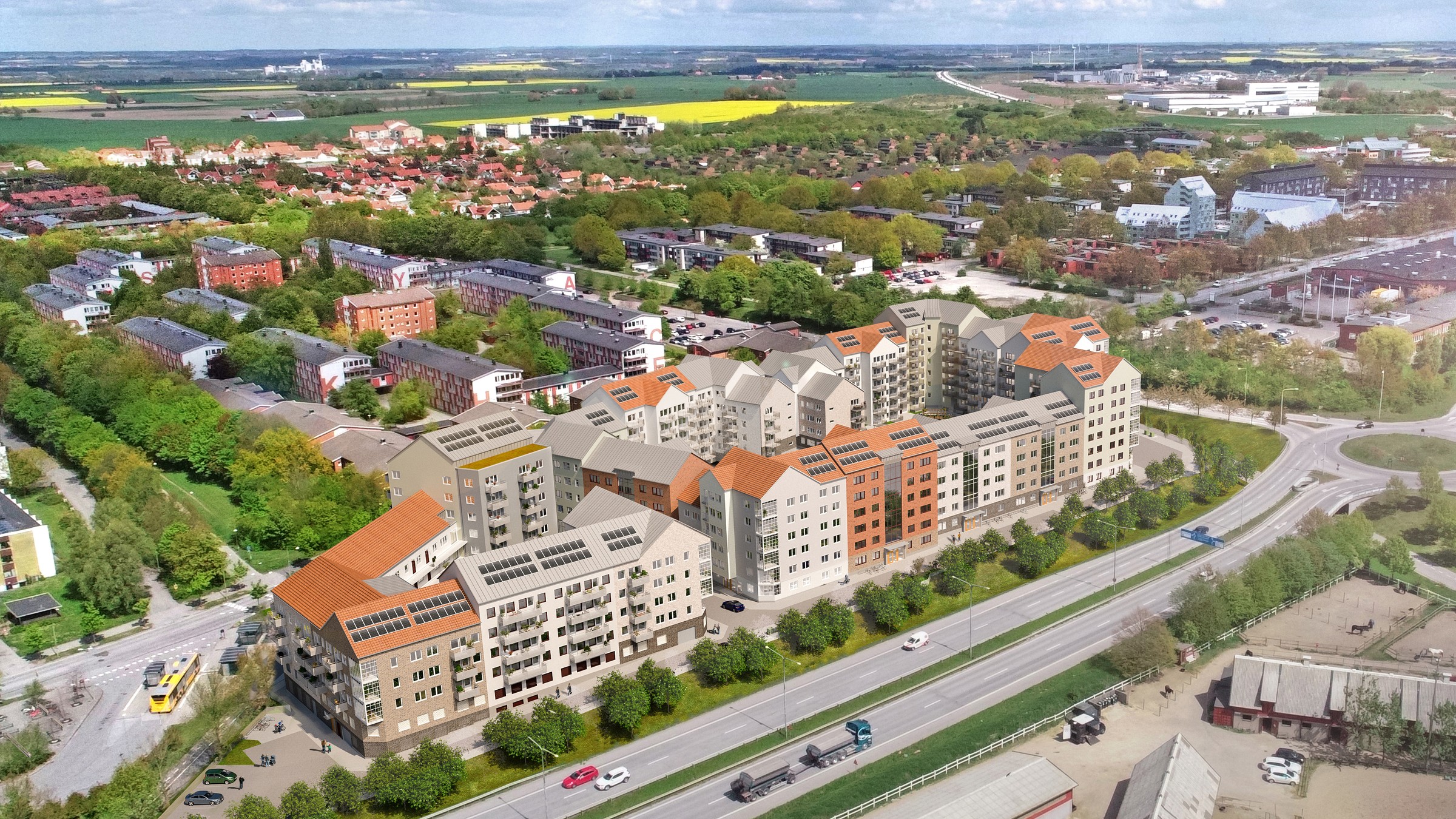 Hyresrättskvarteret Fastighetsboken byggs intill det stora studentområdet Delphi i Lund. Flygvy över modernt lägenhetskomplex omgivet av grönska, vägar och bostadsområde.