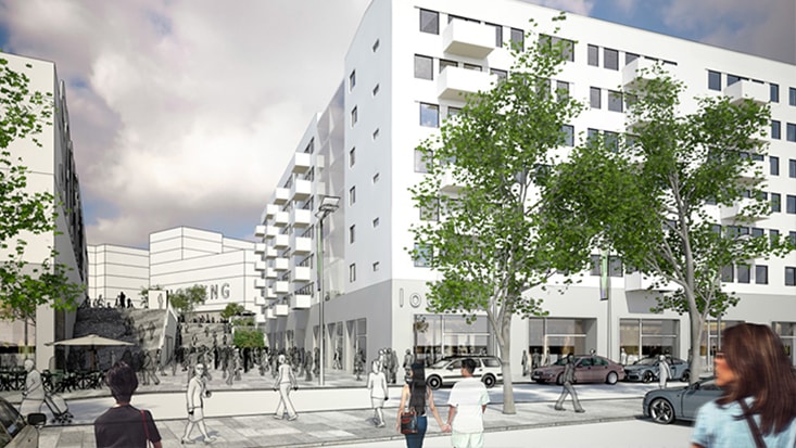Modern stadsplats med människor, träd, bilar och vita fler våningsbyggnader under en molnig himmel.