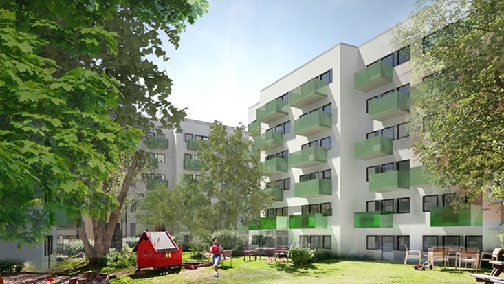 Moderna lägenhetsbyggnader med gröna balkonger och en lekplats i en lummig gårdsmiljö.