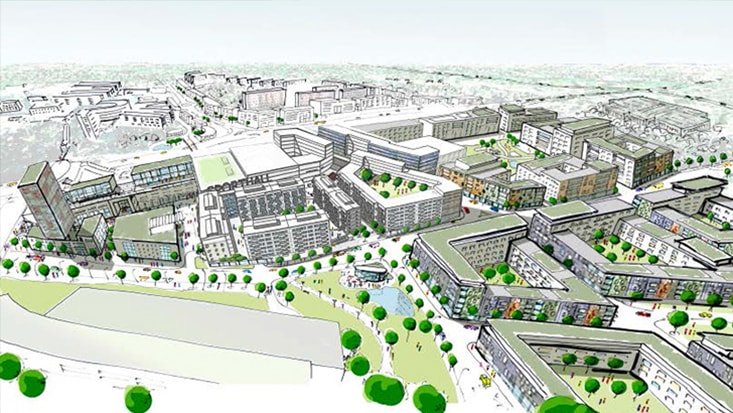 Flygvy över en modern stadsutveckling med grönområden, byggnader och anlagda områden.