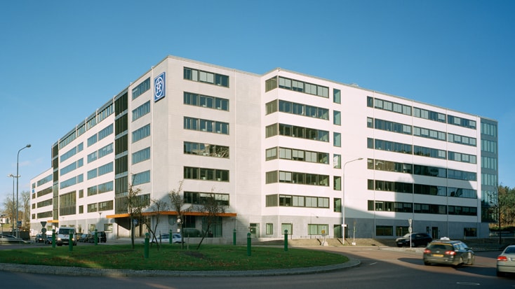 Modern kontorsbyggnad med GE-logotyp, med stora fönster och en dynamisk urban miljö.