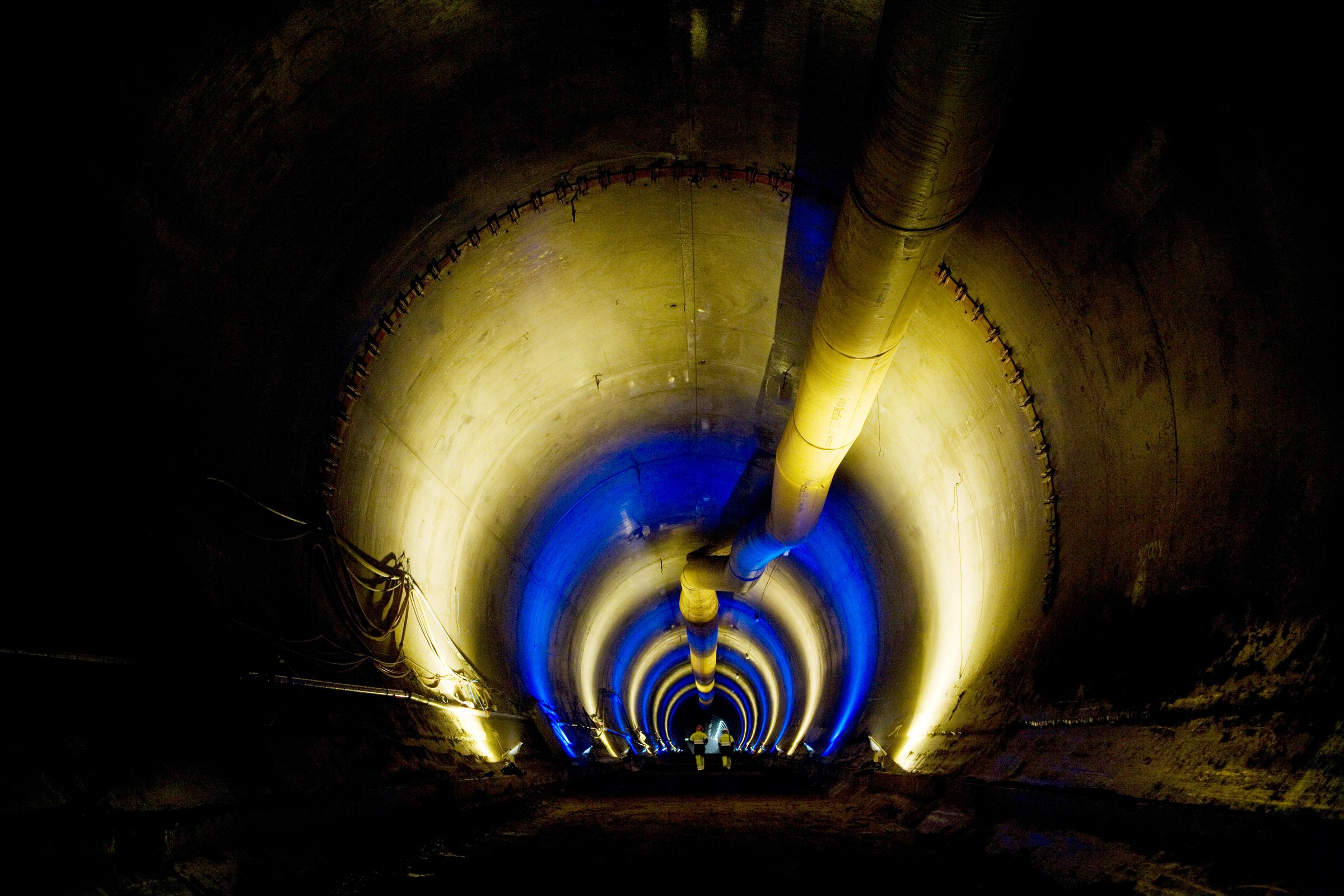 Hallandsås Upplyst tunnel med blå och gula ljus, med ett centralt ventilationsrör.
