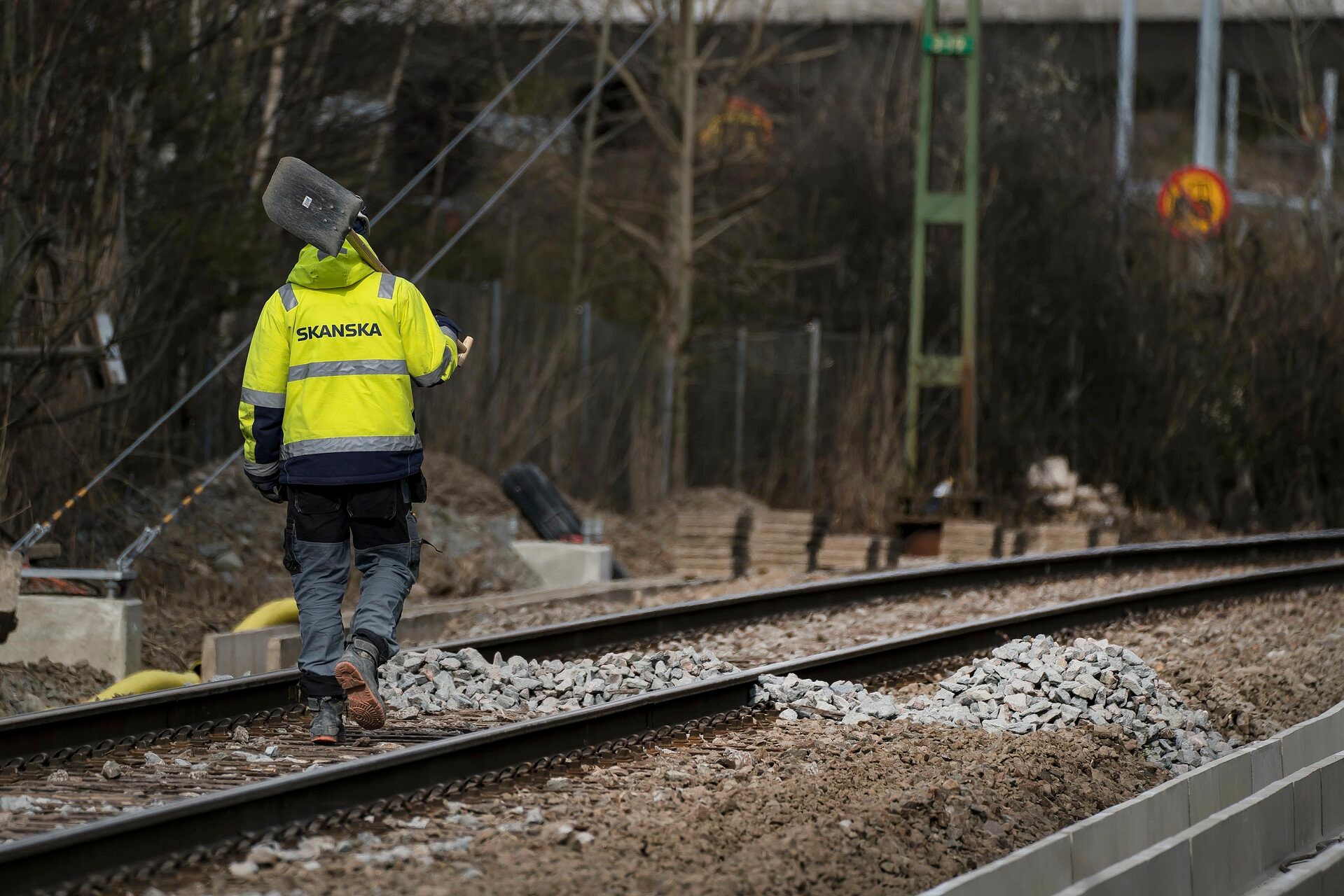 Vårt arbete ute på plats startade i februari 2020. Person i arbetskläder går på järnvägsspår.
