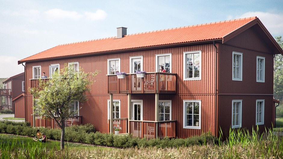 Skanska Hyresbostäders projekt Tölö Trädgårdar. Rött trähus i två våningar med balkonger, omgiven av grönska under en klarblå himmel.