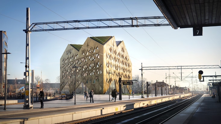 Futuristisk geometrisk byggnad nära järnvägsplattform med människor och spår i stadsbild.
