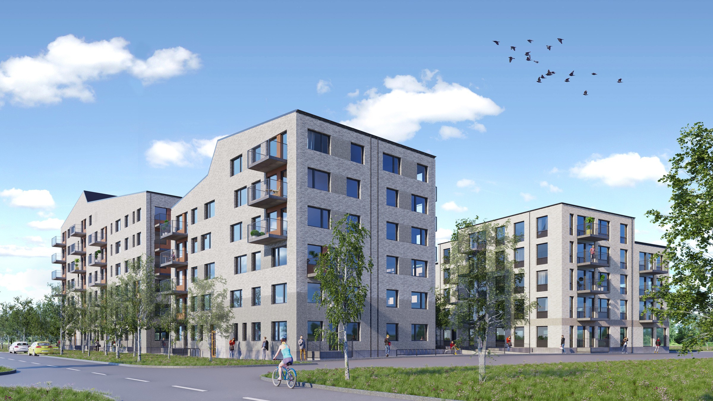 Moderna flerbostadshus med balkonger omgivna av grönska under en klar blå himmel.