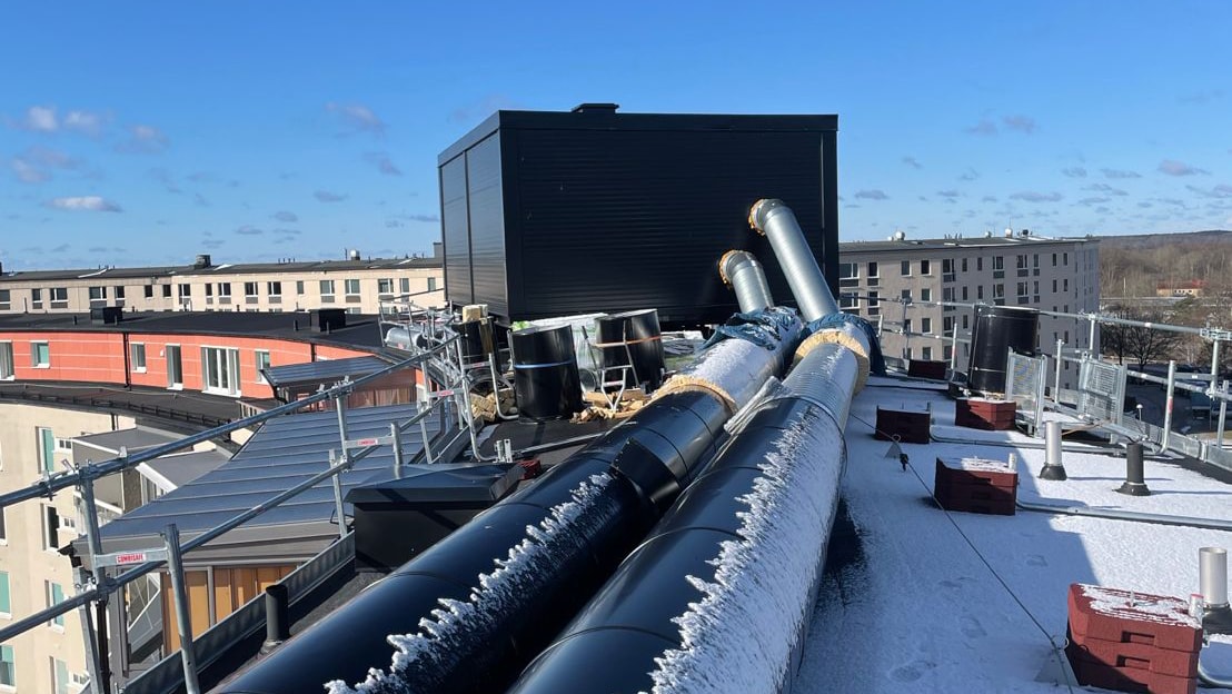 Nya fläktrum och ventilationslösningar har installerats på taket. Ventilationsrör och ny teknikutrustning på snötäckt tak i Karlskrona under Skanskas renoveringsprojekt.