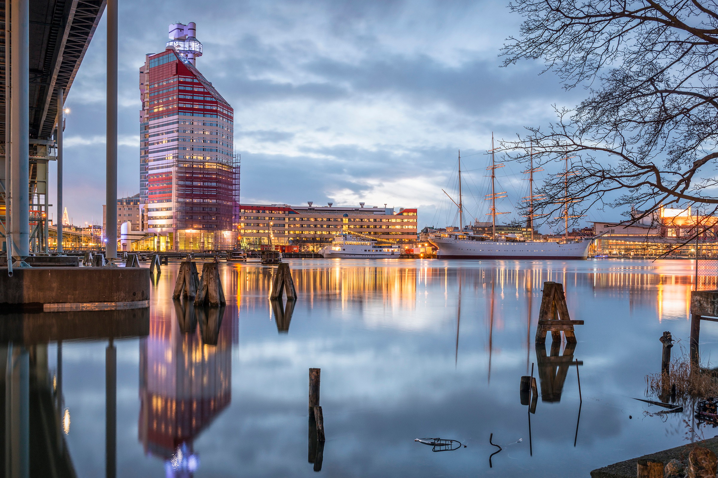 Vattenutsikt över Göteborg med den ikoniska rödvita byggnaden Lilla Bommen vid skymning.