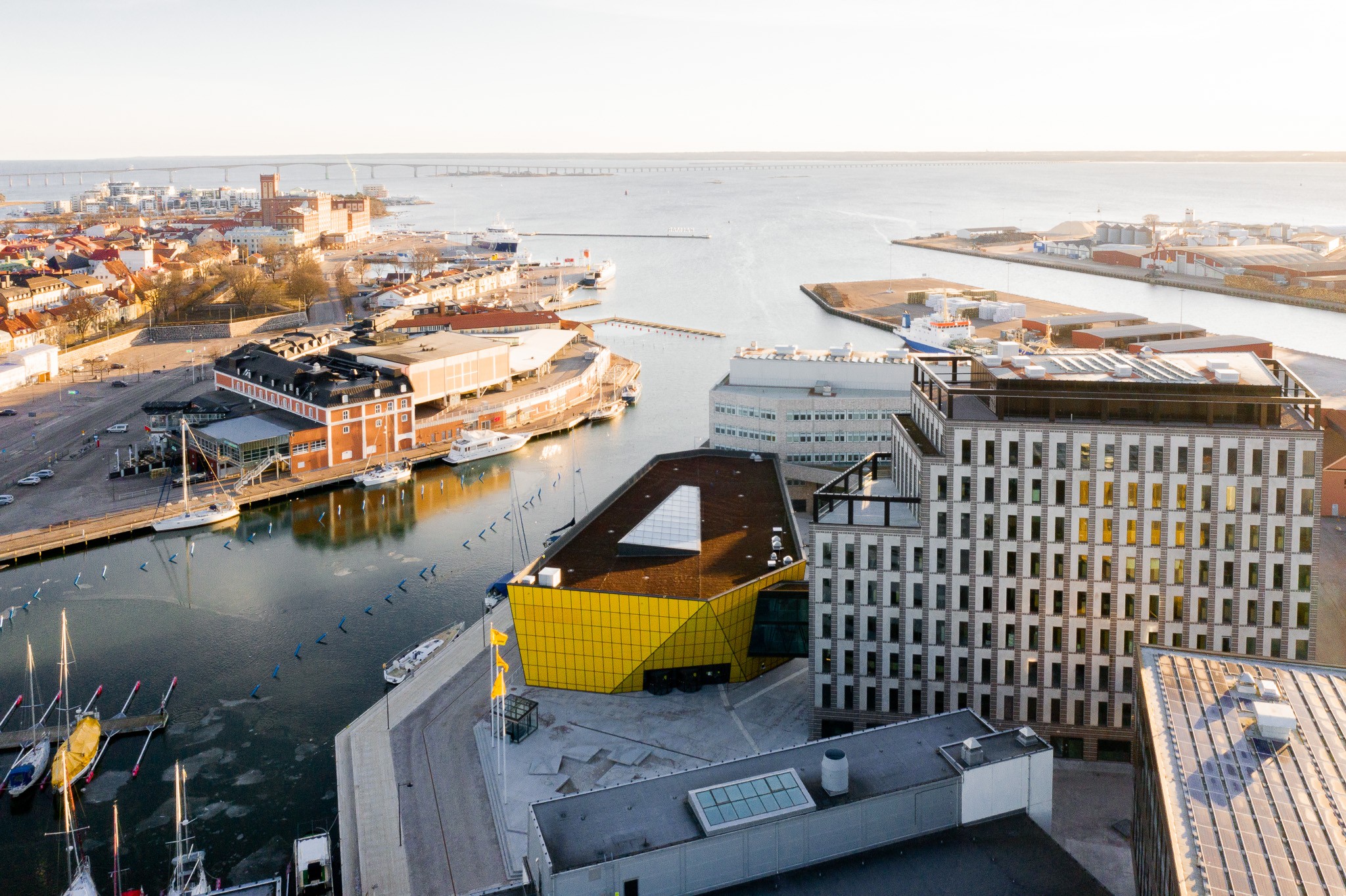 Flygvy över byggnader vid vattnet i Kalmar, Sverige, med modern arkitektur.