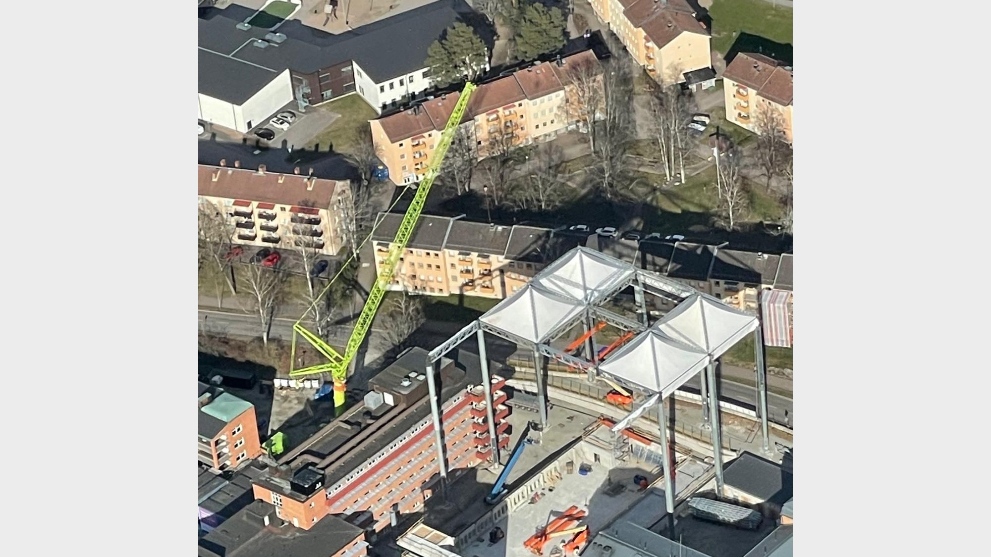 Montage av stomme till det nya mottagningshuset vid Centralsjukhuset i Karlstad. Flygfoto över byggarbetsplatsen vid Centralsjukhuset i Karlstad med stomme under uppförande och grön byggkran i arbete.