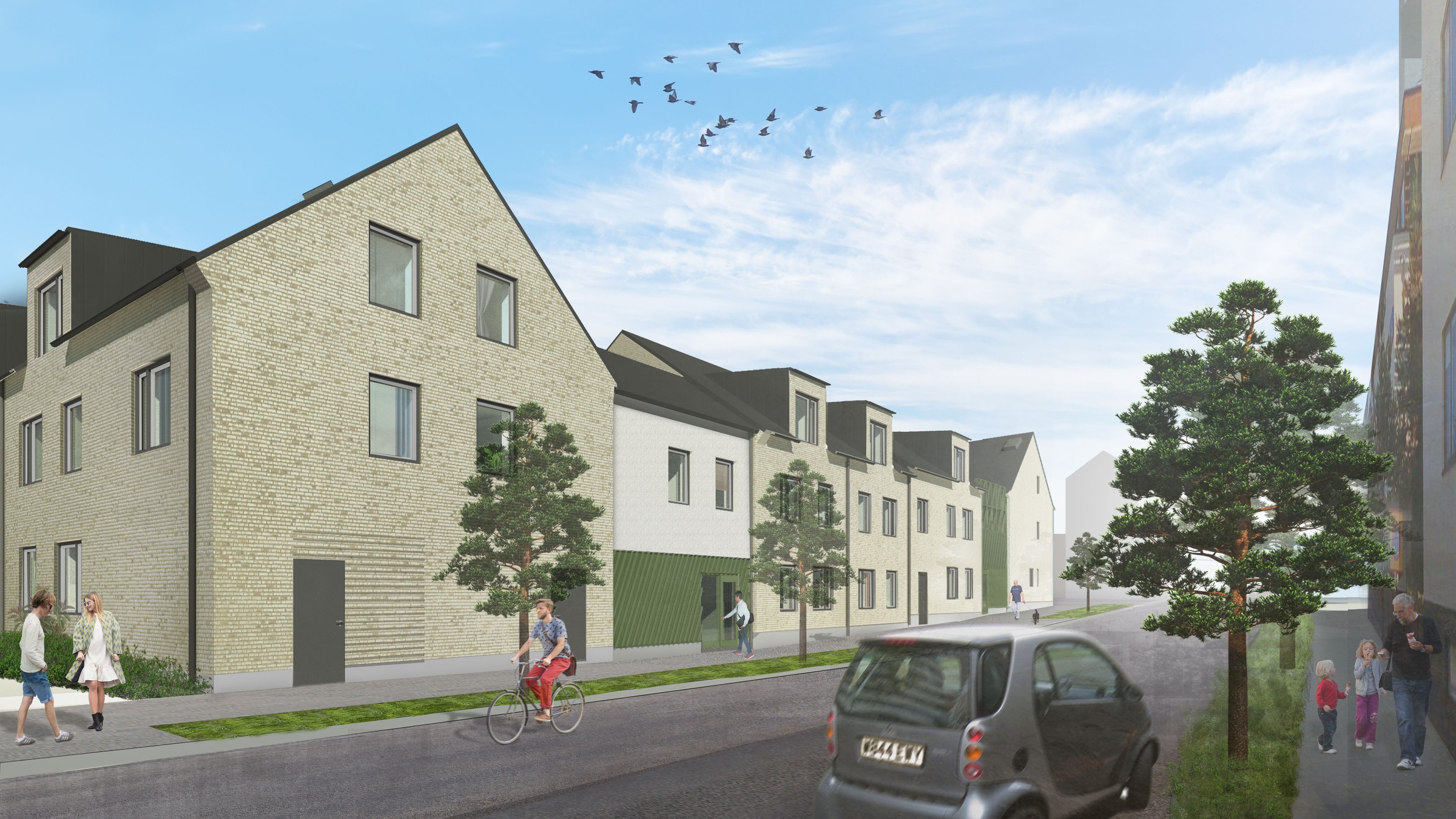 Modern bostadsgata med cyklister, fotgängare, träd och parkerade bilar under en blå himmel.