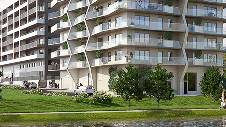 Modern bostadslägenhetsbyggnad med geometrisk fasad, balkonger och gröna omgivningar.