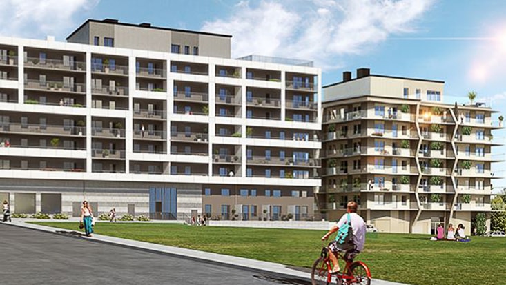 Moderna lägenhetsbyggnader med balkonger, omgivna av grönområden och en cyklist i förgrunden.