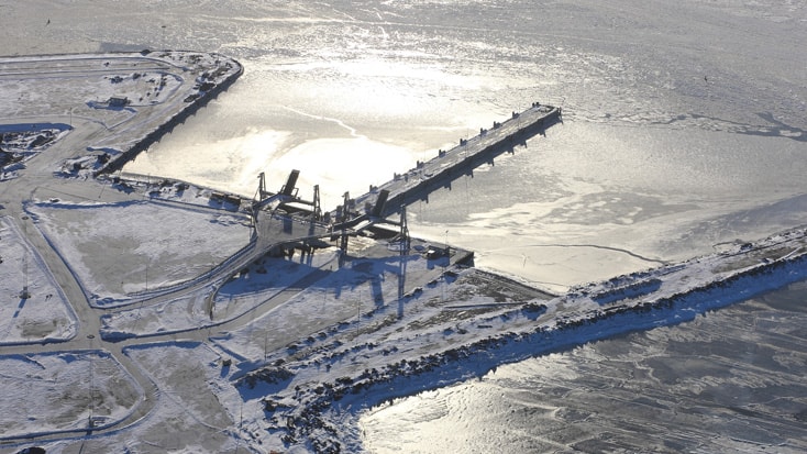 Norra hamnen Flygfoto över en snötäckt industrihamn med frusna vatten och kajstrukturer på vintern.