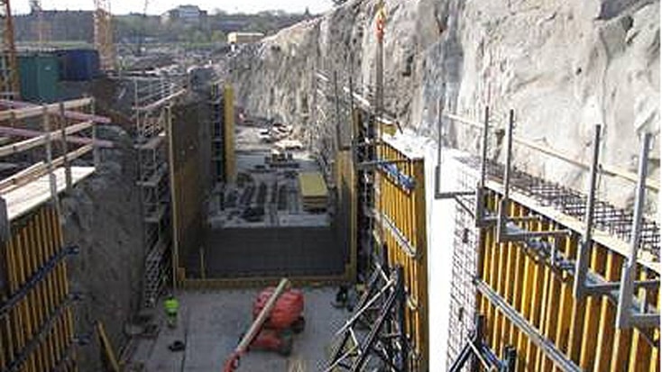 Norra Länken 11 Byggarbetsplats med stora betongformar, byggnadsställningar och bergväggar i ett djupt utgrävningsområde.