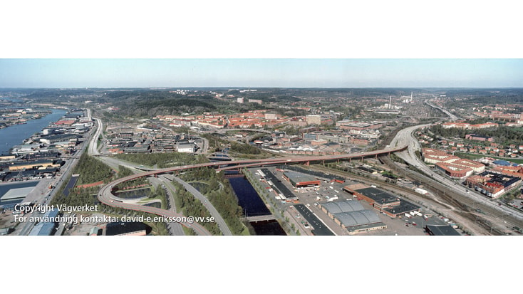 Partihallsförbindelsen Flygvy över en stads industriområde och vattenvägar, som visar infrastruktur och stadslandskap.