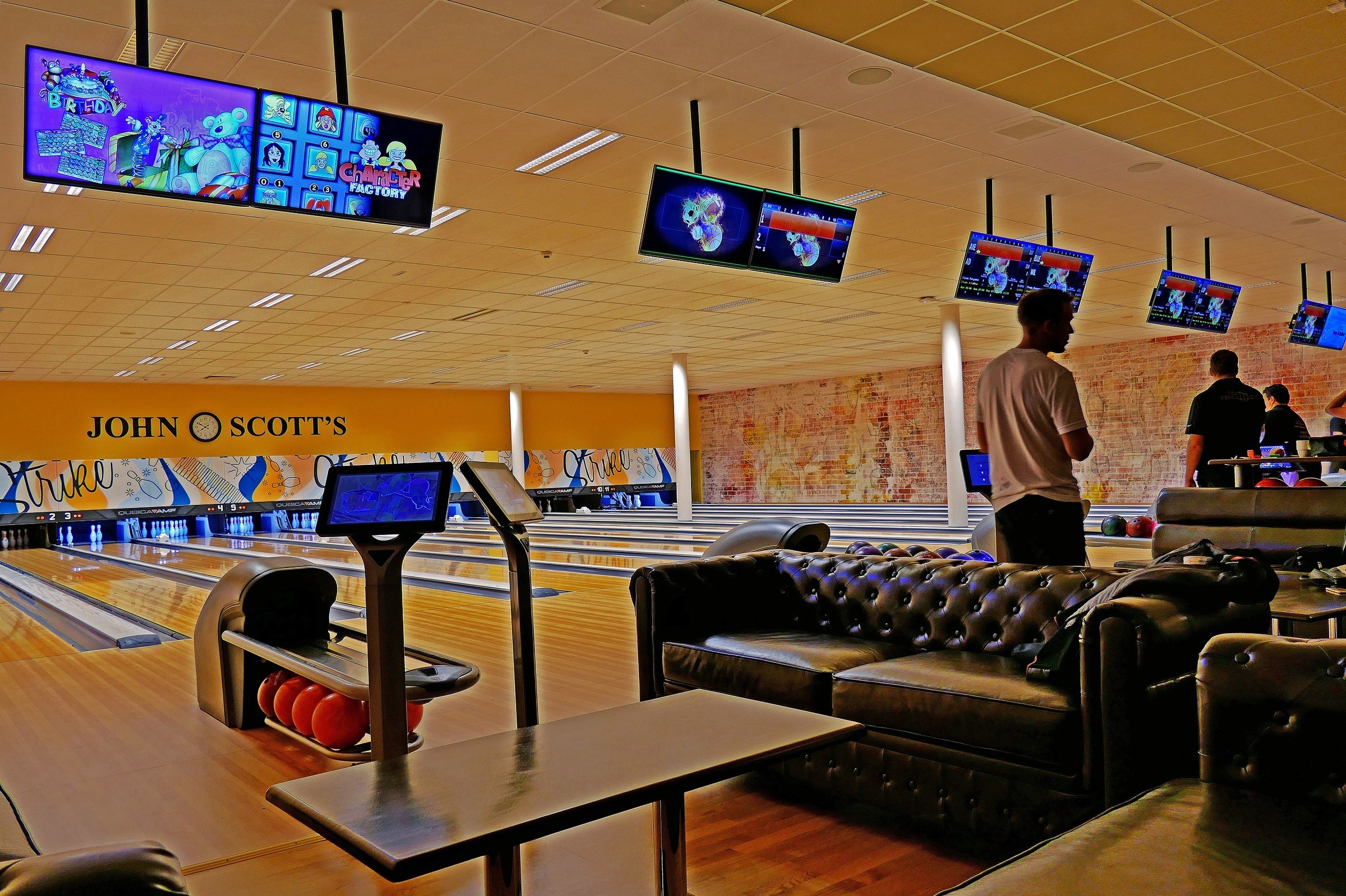 Modern bowlinghall med bekväma sittplatser, digitala resultattavlor och banor redo för spel.