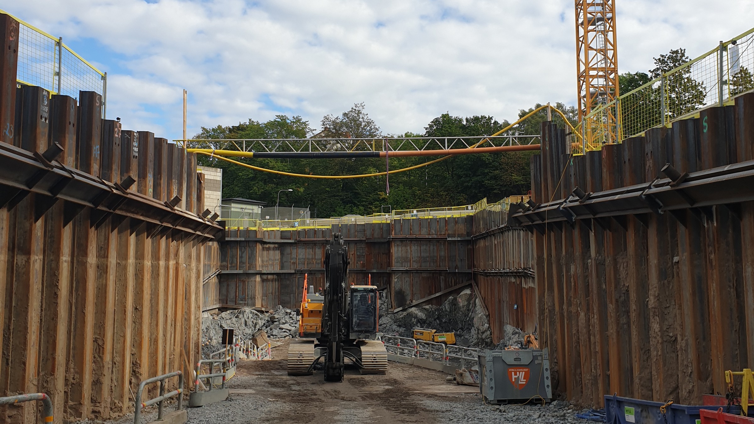 Skanska uppför en byggnad och husinstallationer för en transformatorstation på 400 kV i Mårtensdal i Stockholm. Byggarbetsplats med schaktning med tung maskin och armerade stålvväggar.