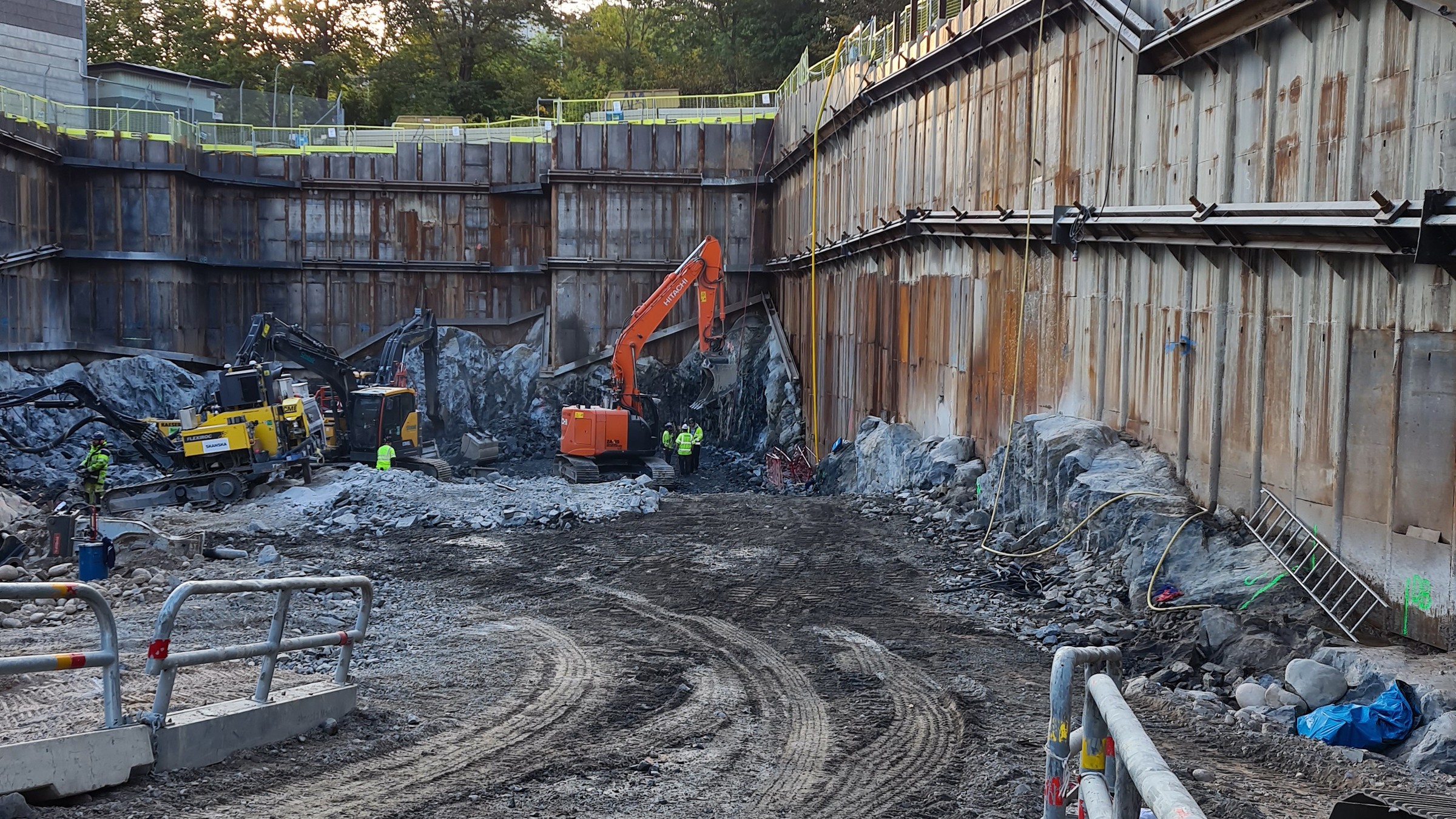 Syftet med kraftstationen är transformering av 400kV till 220kV. Byggarbetsplats med grävmaskiner som arbetar i en djup, förstärkt grop omgiven av betongväggar.