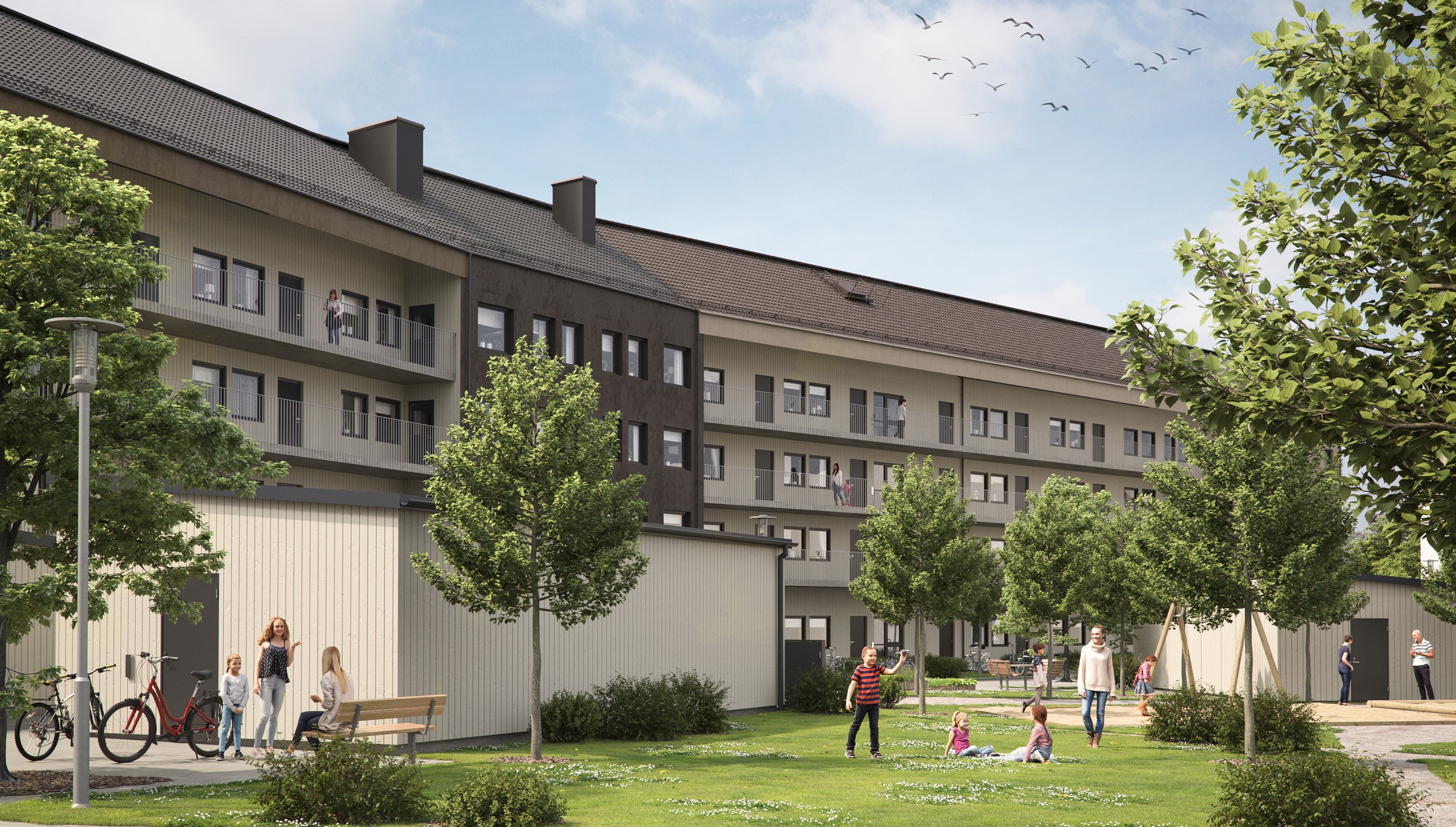 Modernt lägenhetskomplex med grönområden, träd och människor som njuter av utomhusaktiviteter.