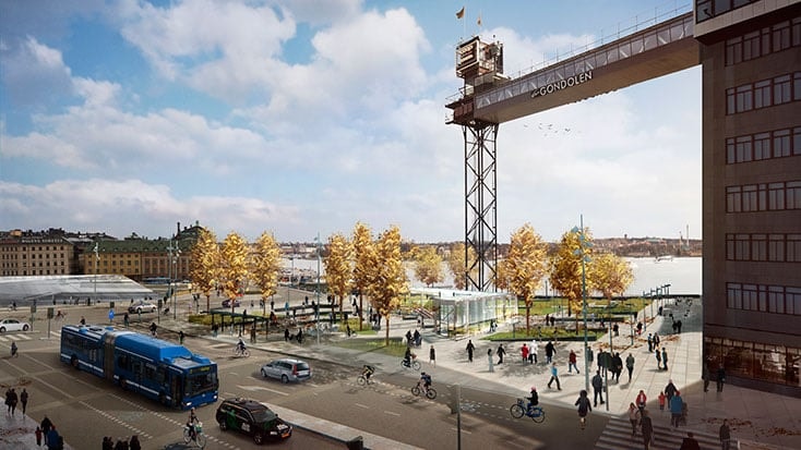 En livlig stadsbild med fotgängare, cyklister och fordon nära en strandlinje och upphöjd struktur.