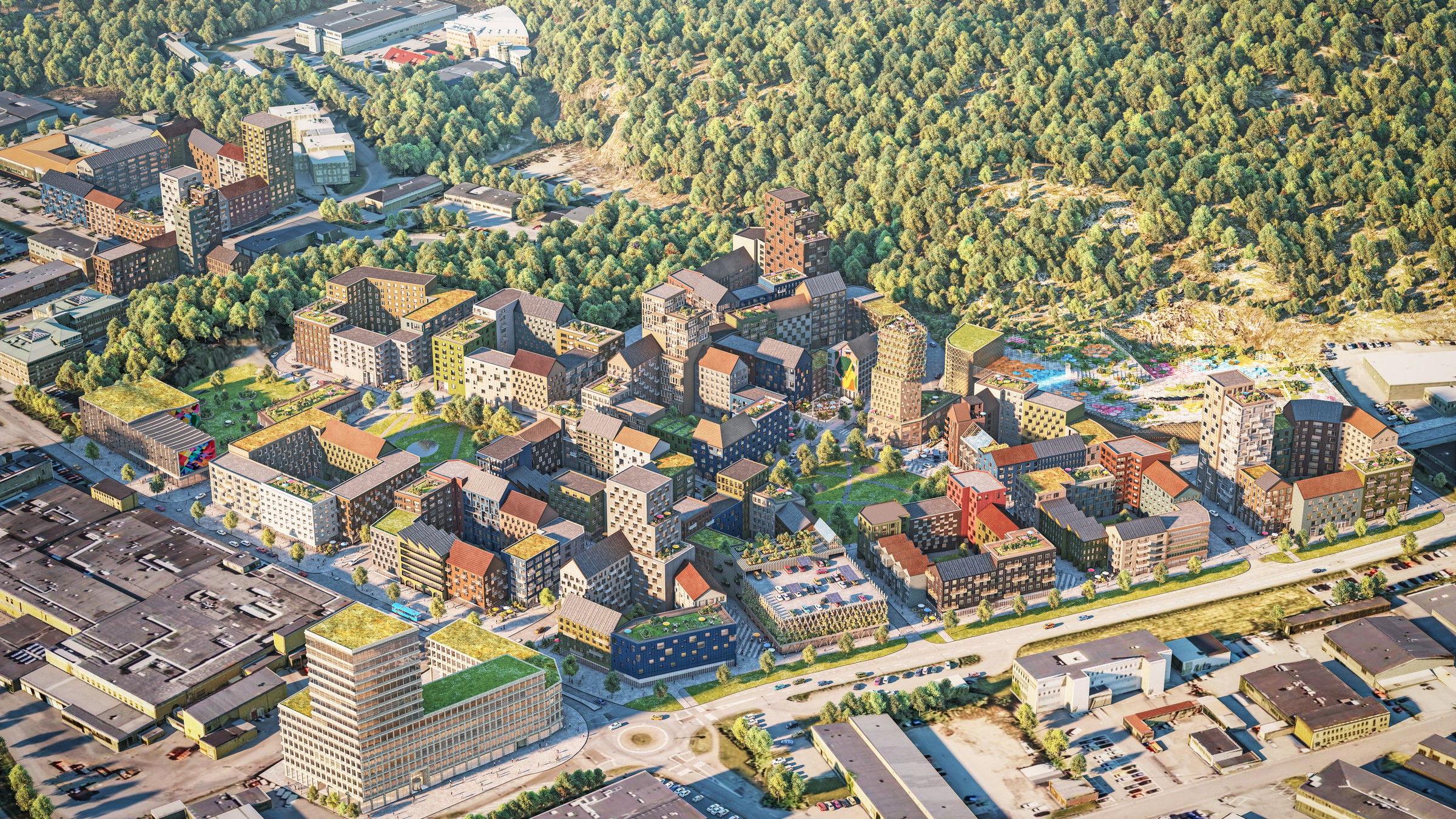 Flygvy över ett modernt bostadskomplex omgivet av frodig grönska och urban infrastruktur.