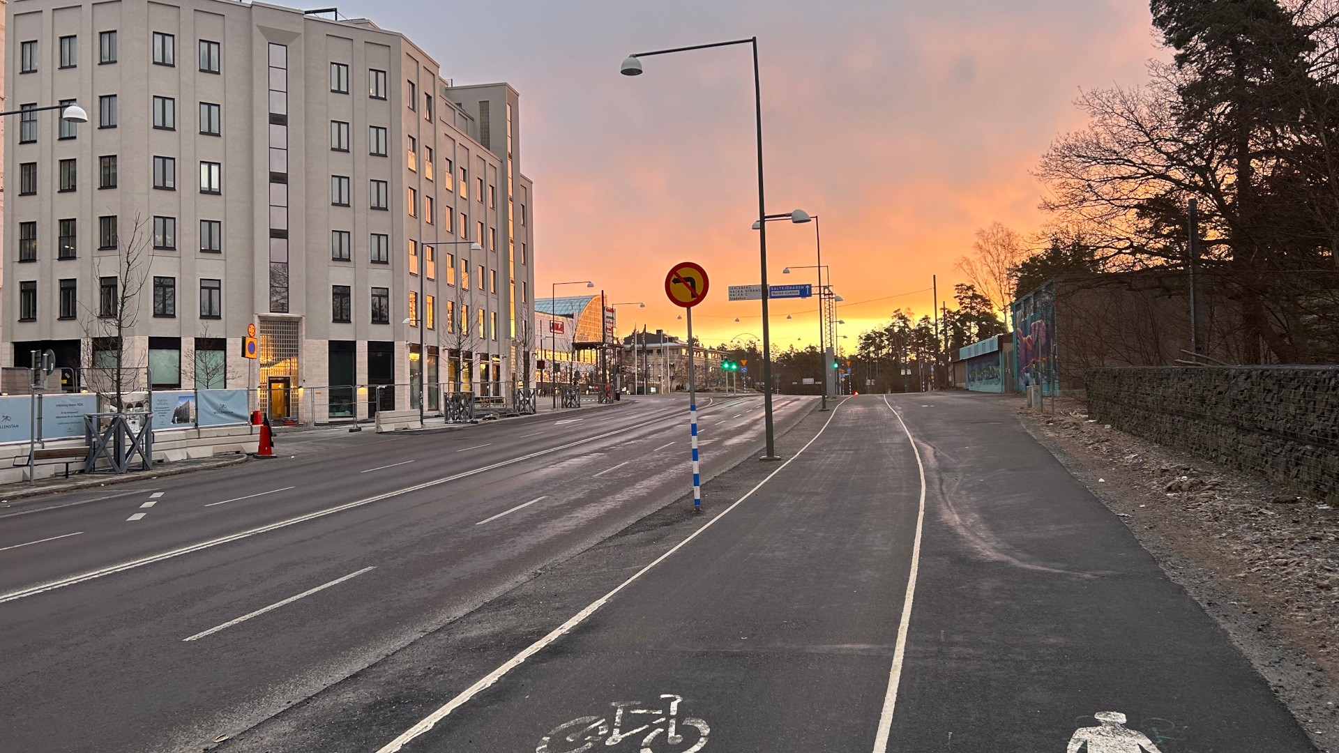 Arbetsplatsen omges av trafikerade vägar med bilar, bussar, gående och ett regionalt cykelstråk. Cykel och gångbana i Nacka i kvällsljus.