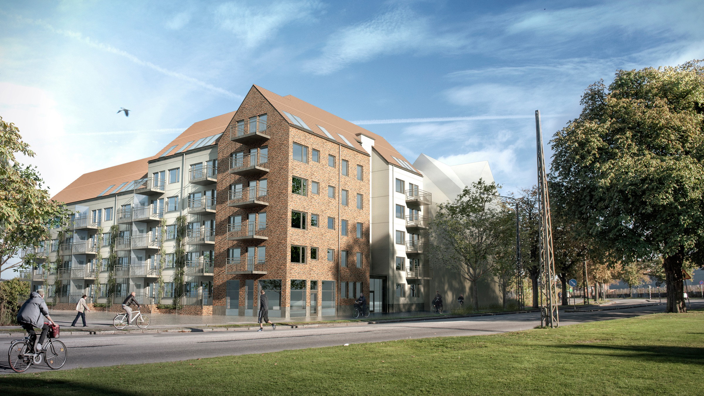 Modern lägenhetsbyggnad med tegelfasad, glasbalkonger och cyklister på en solig gata.