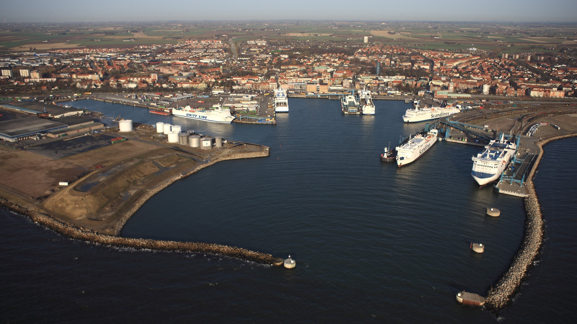 Trelleborgs hamn Flygvy över en livlig kusthamn med flera fartyg förtöjda och en stad i bakgrunden.