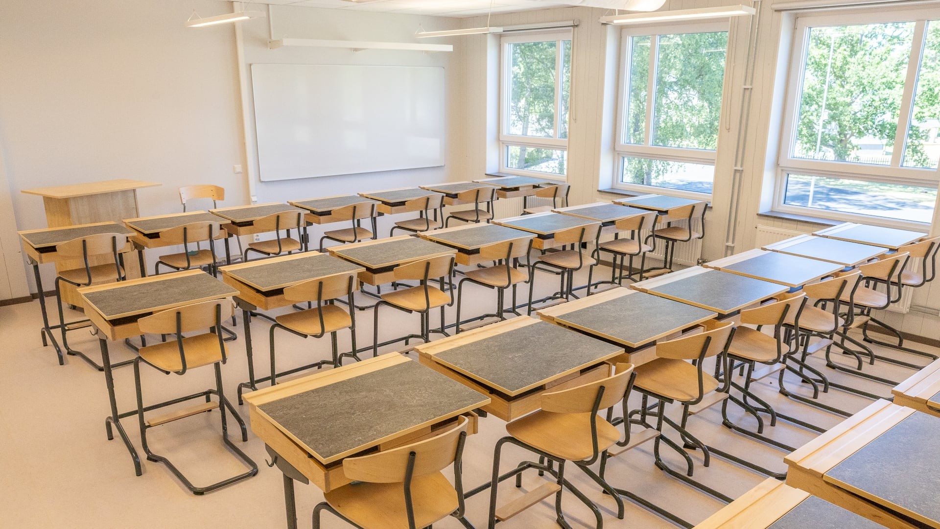 Klassrum i Västerängsskolan med träbord, stolar och stora fönster.