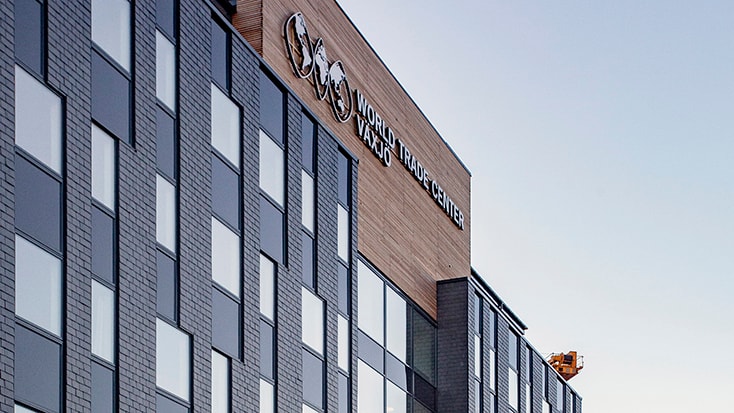 Exteriör av World Trade Center Växjö-byggnaden med moderna glasfönster och tegelfasad.