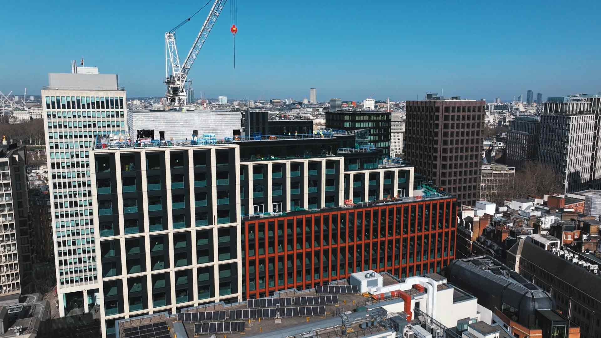 A cityscape featuring modern office buildings with a construction crane in the background.