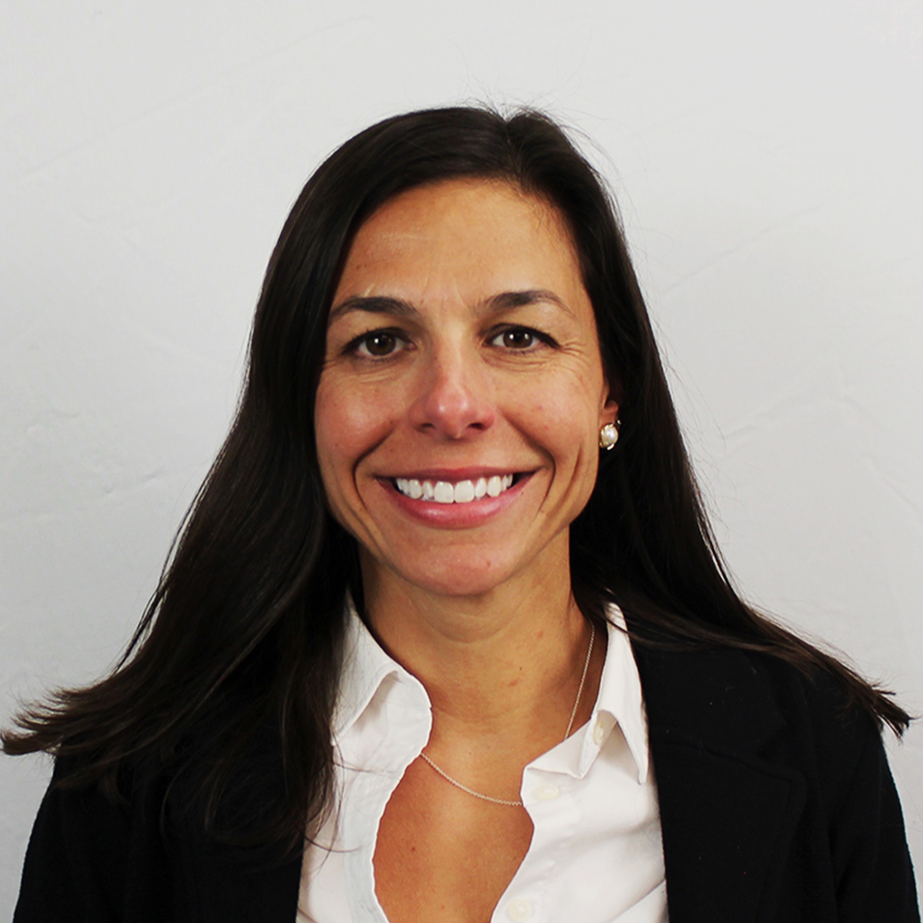 Professional woman with long dark hair wearing a white shirt and black blazer.