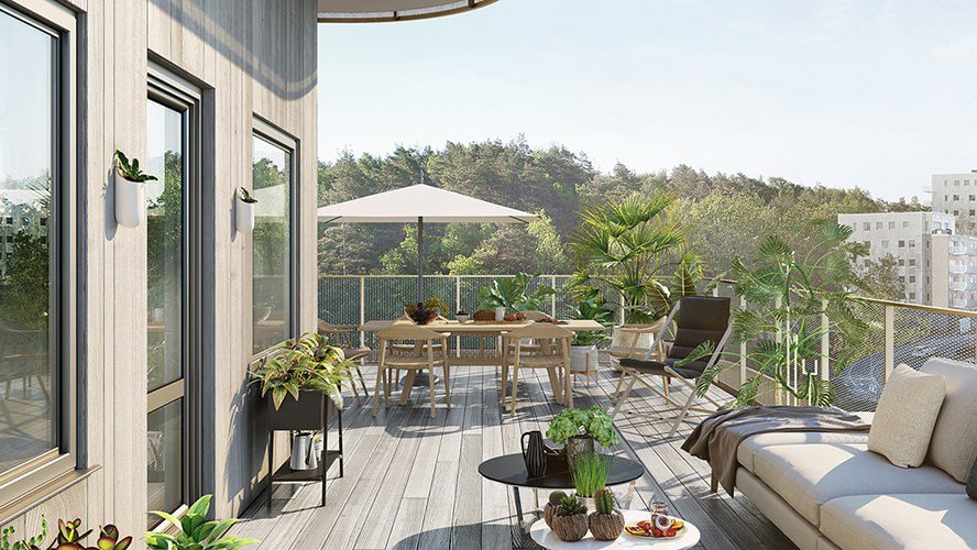 Stylish terrace with cozy seating, lush greenery, and a scenic view of trees under a clear sky.