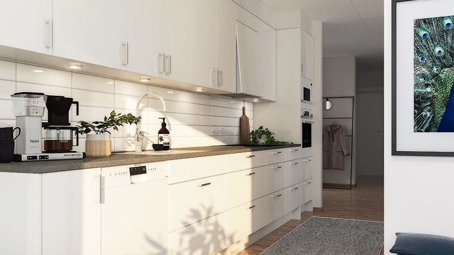 Modern kitchen with white cabinets, gray countertops, built-in appliances, and wall art.