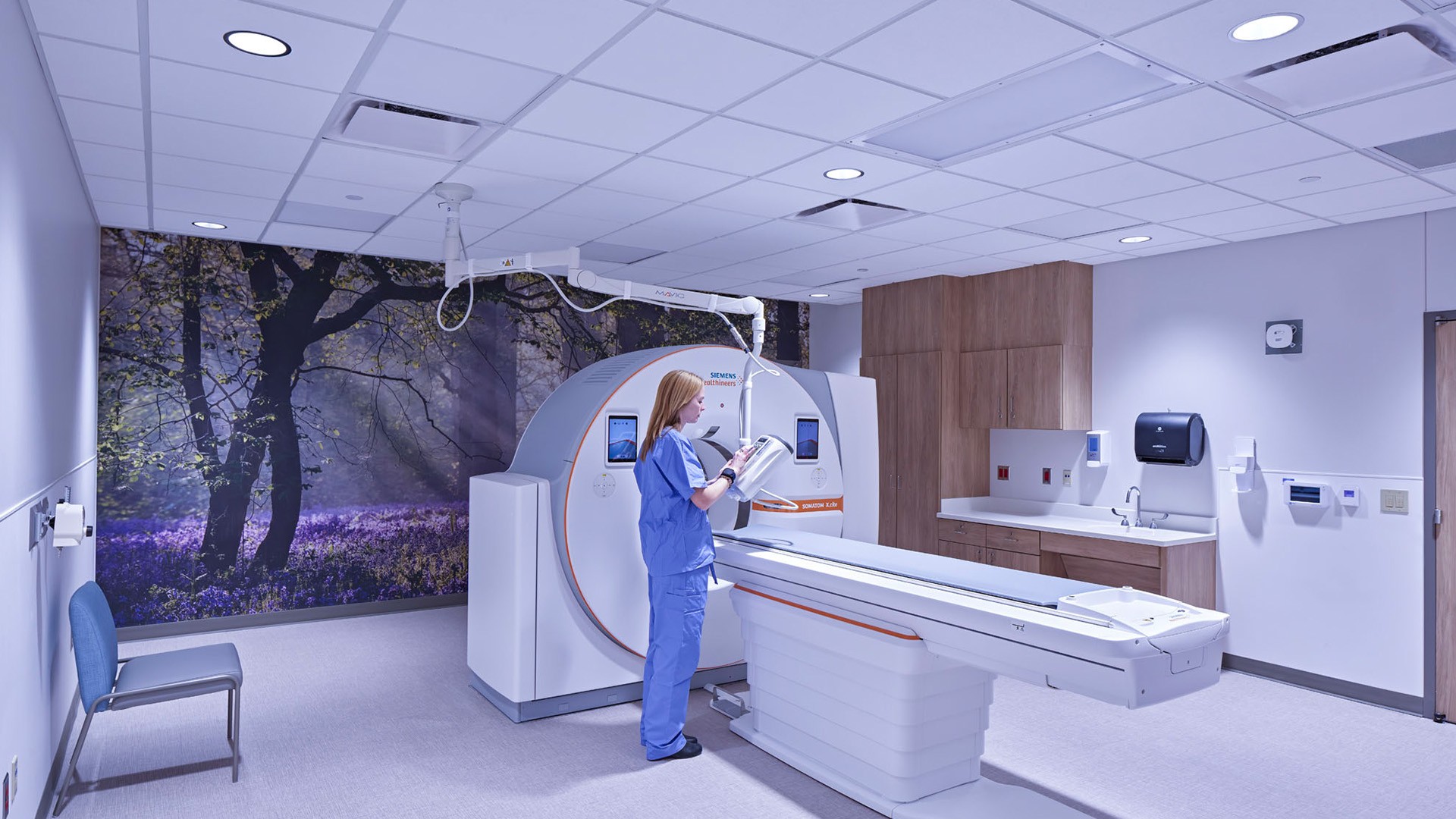Technician Operating Advanced CT Scanner in Modern Imaging Room Medical professional operating a CT scanner in a modern, clean imaging room.