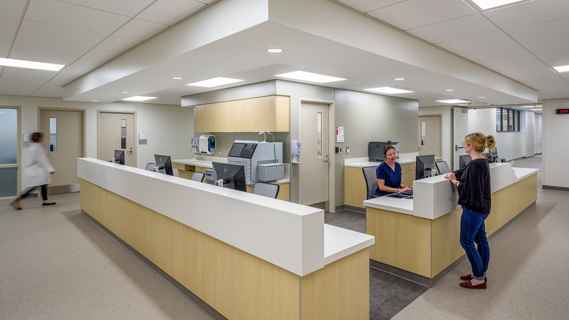 Modern Hospital Nurse Station with Staff Assisting Patient Modern hospital nurse station with staff assisting a patient in a clean medical facility.