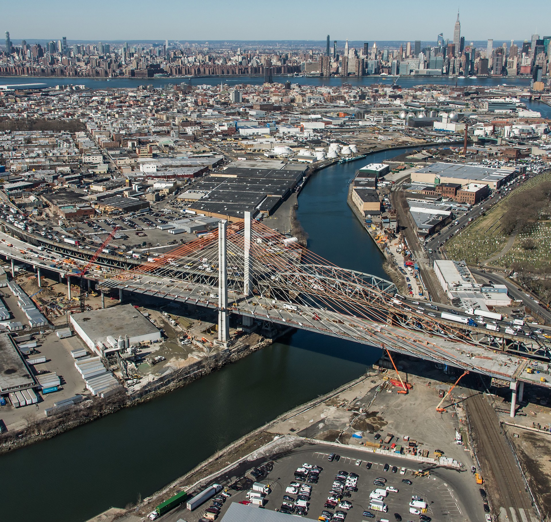 New York City bridge over river with urban skyline view Aerial view of a cable-stayed bridge under construction over a river in an urban area.