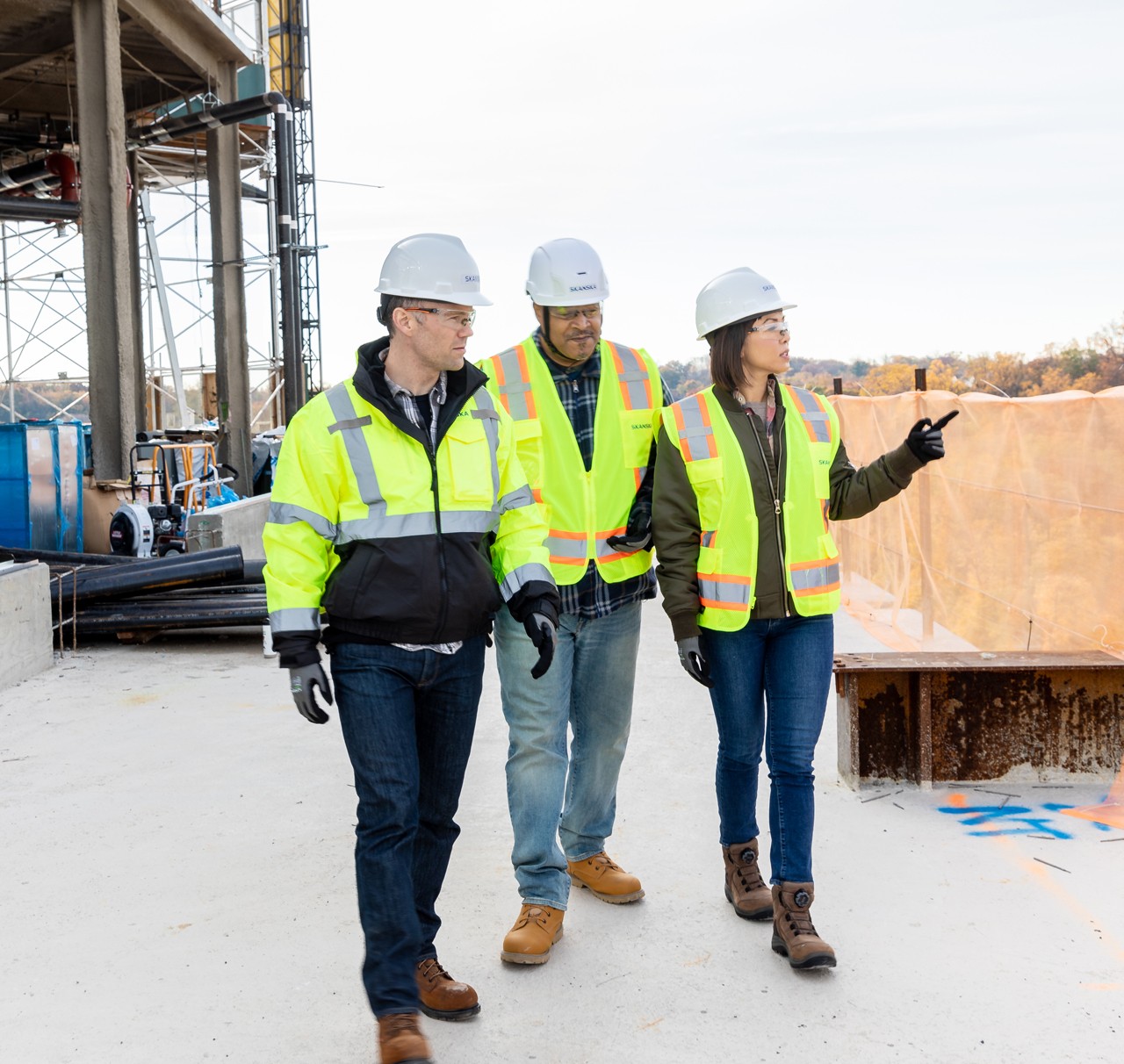 Construction workers in safety gear inspecting site outdoors